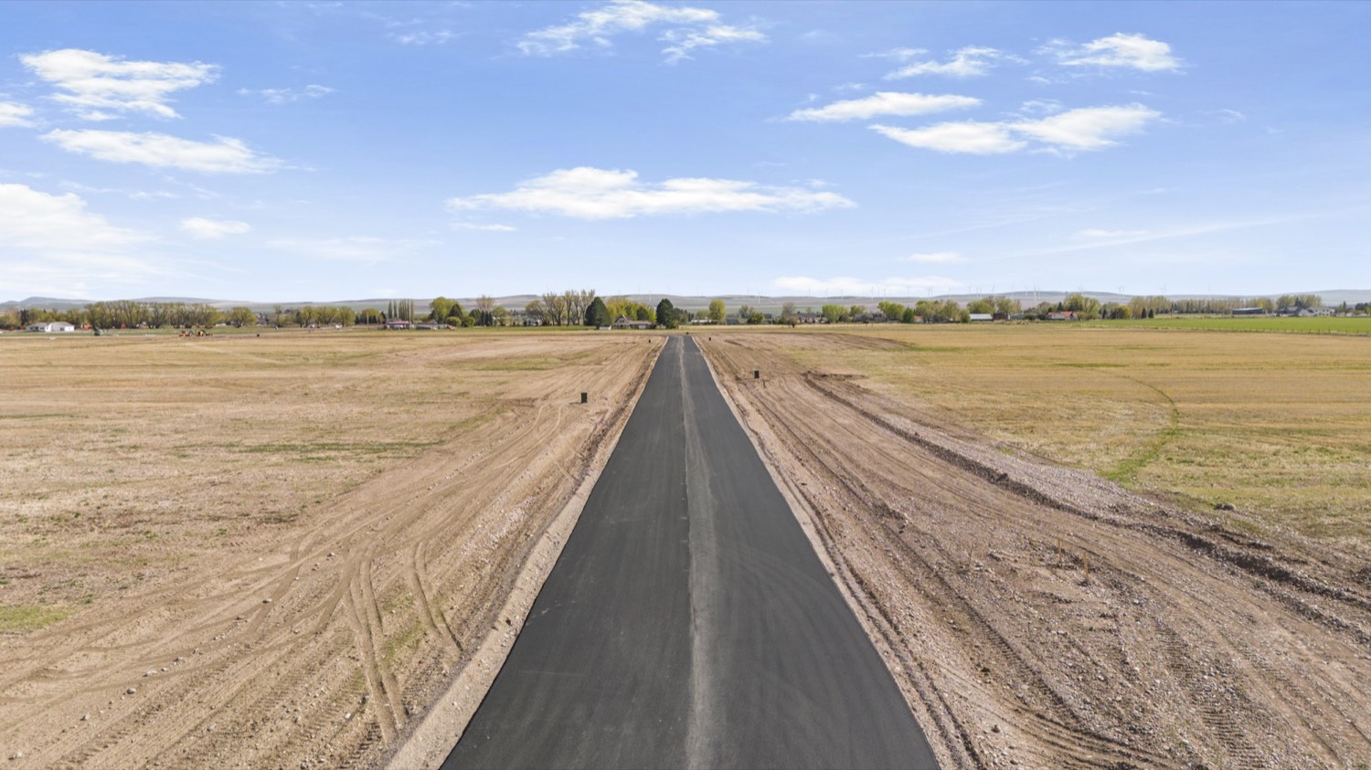 New paved road running through Sunset View Estates toward the foothills